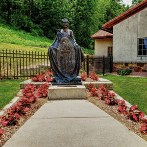 flower-path-juan-diego-statue-shrine-our-lady-guadalupe-church-la-crosse-wisconsin-gallery Statue depicting Mary appearing on Juan Diego's cloak at Our Lady of Guadalupe Shrine in La Crosse, Wisconsin.