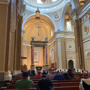 interior-church-pews-people-shrine-our-lady-guadalupe-church-la-crosse-wisconsin-gallery Congregation members sitting in pews during mass at Our Lady of Guadalupe Shrine in La Crosse, Wisconsin.