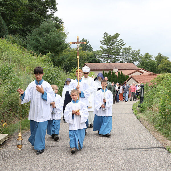 A group of altar server boys and a Norbertine Priest walk the uphill procession for the devotion of Our Lady of Fatima. A group of altar server boys and a Norbertine Priest walk the uphill procession for the devotion of Our Lady of Fatima.