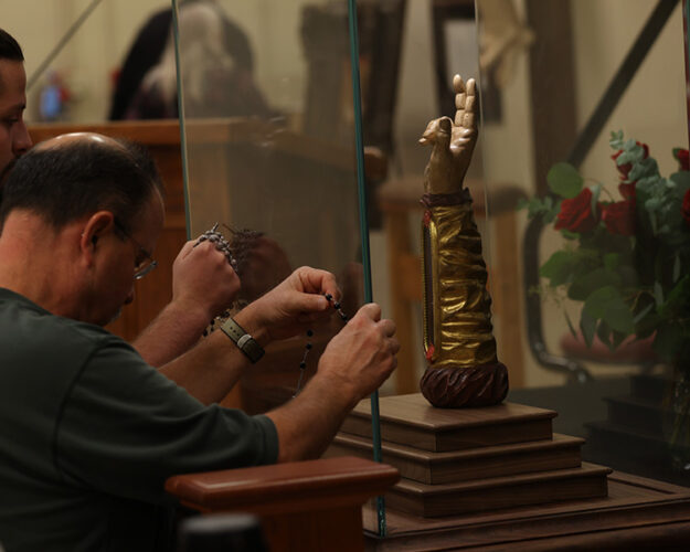 Men creating a third class relic from the Arm of St. Jude Men creating a third class relic from the Arm of St. Jude