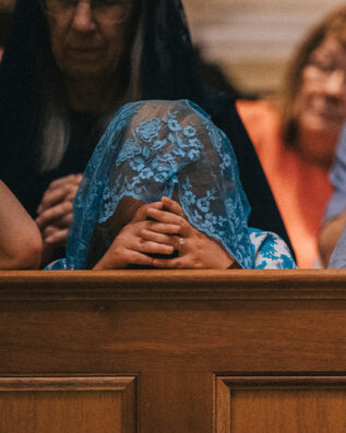 Young lady praying in Guadalupe Shrine pews Young lady praying in Guadalupe Shrine pews