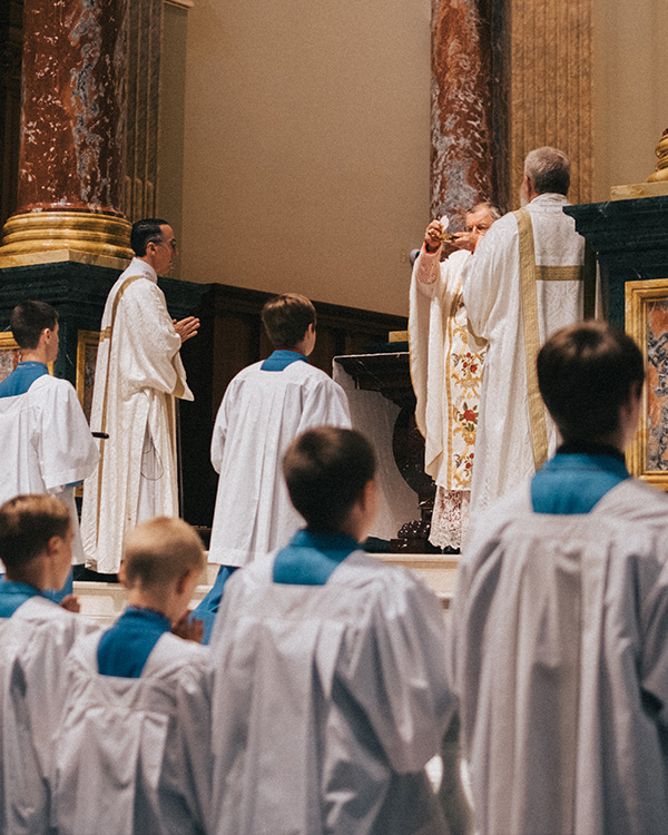 Cardinal Burke presenting the Eucharist with Deacons and Altar servers preparing to receive Cardinal Burke presenting the Eucharist with Deacons and Altar servers preparing to receive