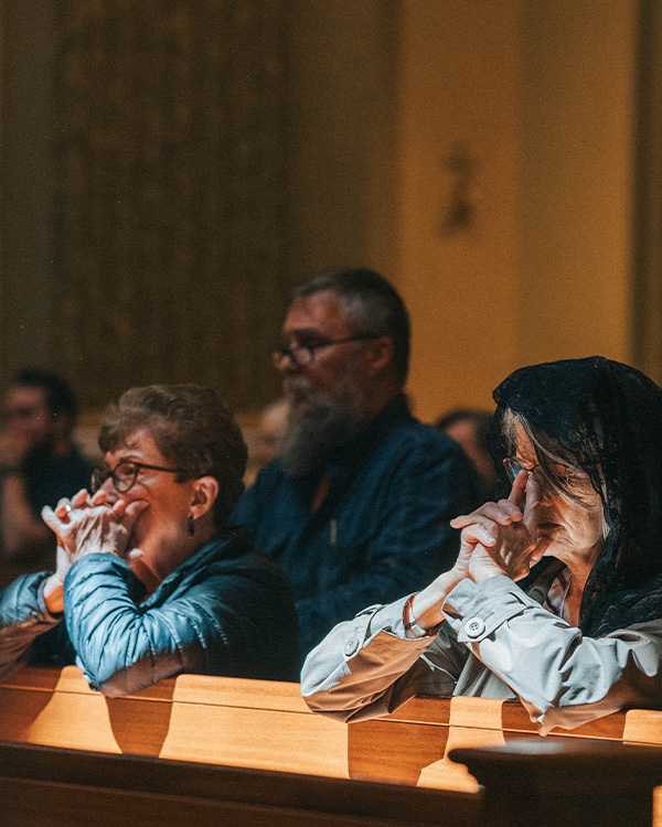 The faithful praying in the Shrine Church pews The faithful praying in the Shrine Church pews